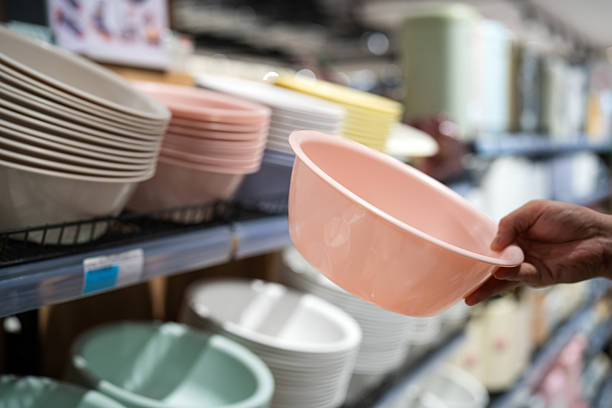 Asian man buying plastic basins in supermarket