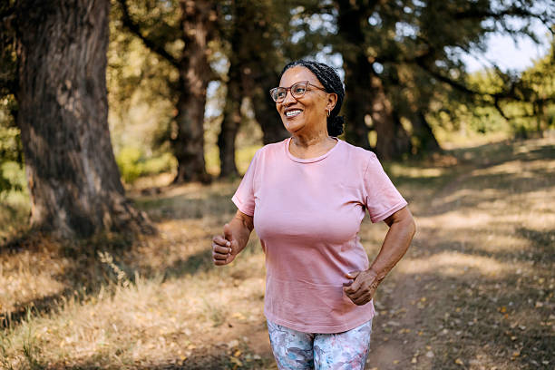istock Smiling mature woman running at public park 2232667944