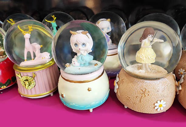 A transparent glass snow globe with a toy inside, on a stand, in  shop window. Decorative interior decoration for the house.
