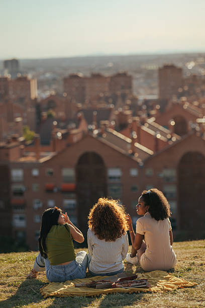 istock Young women enjoying picnic with cityscape view 2232668615