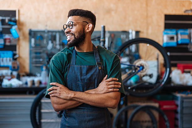 istock Smiling bicycle mechanic crossing arms in workshop 2232668645