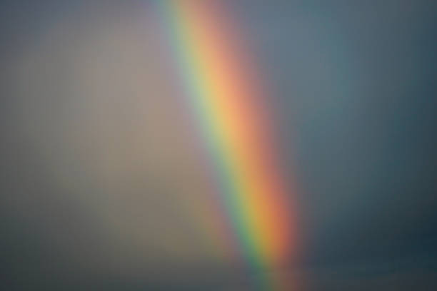 Colorful rainbow arching over urban buildings after rainfall, symbolizing hope, peace, and natural beauty in a city landscape