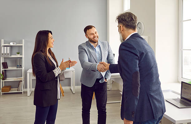 istock Two smiling male business partners shaking hands in office 2232670180