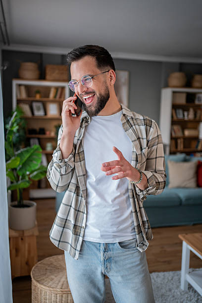 istock Young man talking on phone and gesturing in living room 2232672248