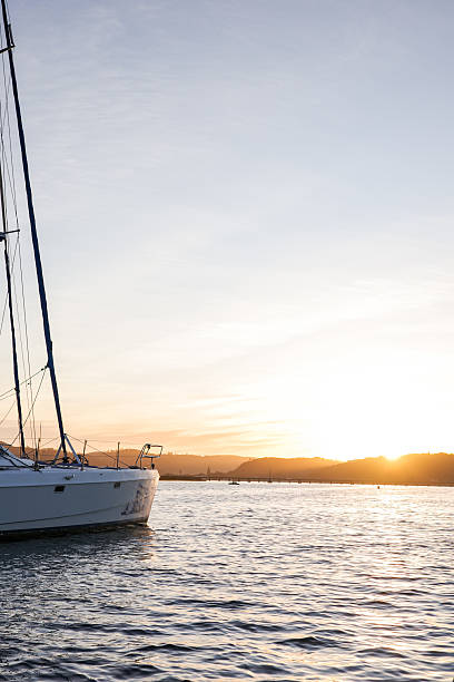 istock A tranquil sailing boat rests on calm waters at sunset, with the golden light reflecting across the sea and soft pastel skies in the background 2232674995