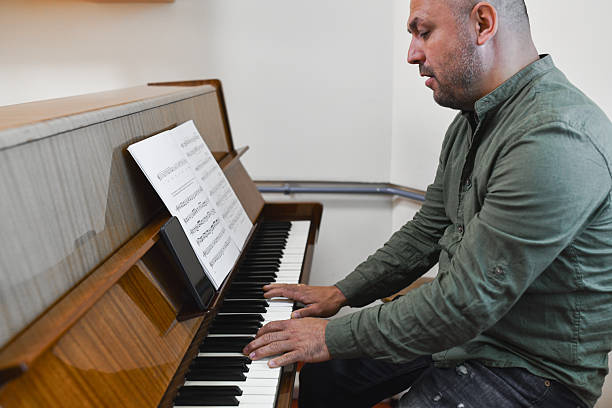 istock Male Pianist Concentrating Deeply While Passionately Performing Elegant Piano Composition 2232677464