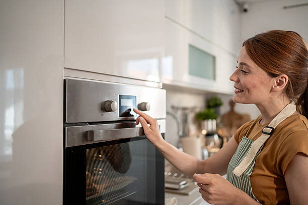 istock Woman using modern oven in contemporary kitchen 2232678074