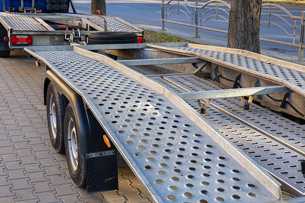 istock A metallic trailer stands parked on a city sidewalk, showcasing its unique surface design and structural components under bright daylight 2232680068