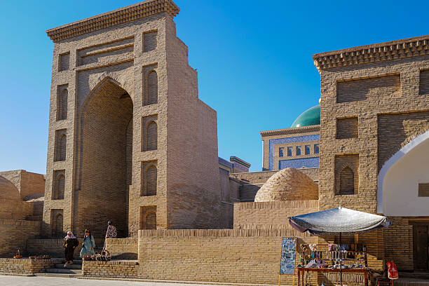 Khiva, Uzbekistan, 05 august 2025: Editorial image capturing the historic skyline of Khiva, Uzbekistan, with a panoramic view of Itchan Kala, the walled inner city and UNESCO World Heritage Site. Dominating the scene is the iconic Kalta Minor Minaret, with its striking turquoise tiles, alongside the Mohammed Amin Khan Madrassah and the ancient city walls. This compact medieval town showcases traditional Central Asian architecture, including domes, minarets, and narrow alleys. Khiva was once a major Silk Road trading post and remains one of the best-preserved examples of Islamic architecture in the region. The photo reflects the timeless charm and cultural richness of this historic Uzbek city