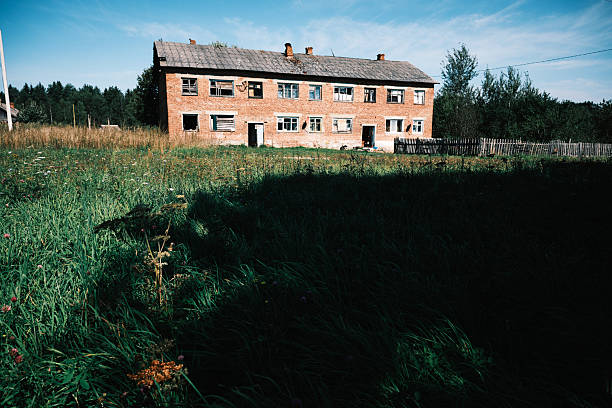 Wide view of deserted Soviet apartment buildings in Irbene, Latvia. Post Soviet ghost town with concrete architecture, overgrown greenery, no people. Irbene, Latvia, 18 June 2025
