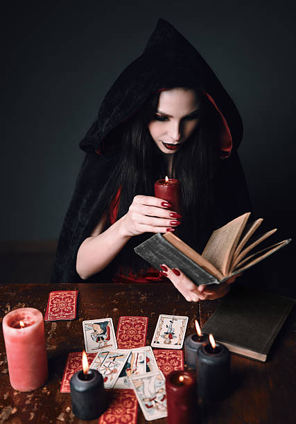 istock Dark beauty: mysterious young sorceress reading the spellbook. P 2232686432