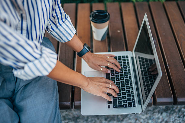 istock Businesswoman working on laptop outdoors with coffee 2232686490
