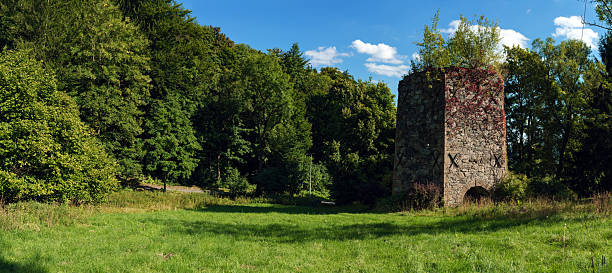 19th-century stone lime kiln in Leszczyniec, Lower Silesia, Poland, stands as an immovable heritage monument with weathered masonry, moss accents, and rustic industrial charm amid verdant surroundings