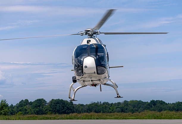 istock White Airbus H120 helicopter hovering front view over runway and trees 2232688972