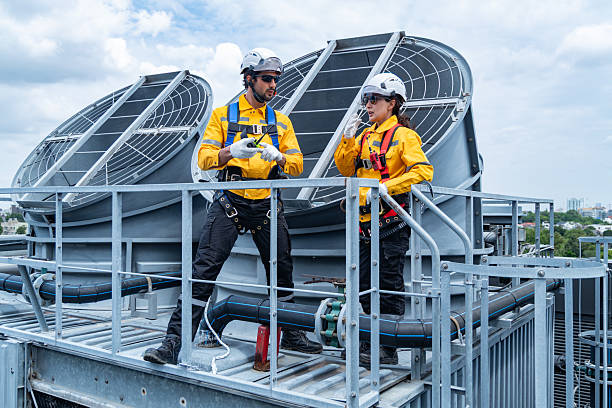 istock Architects reviewing blueprints on rooftop HVAC system 2232692372