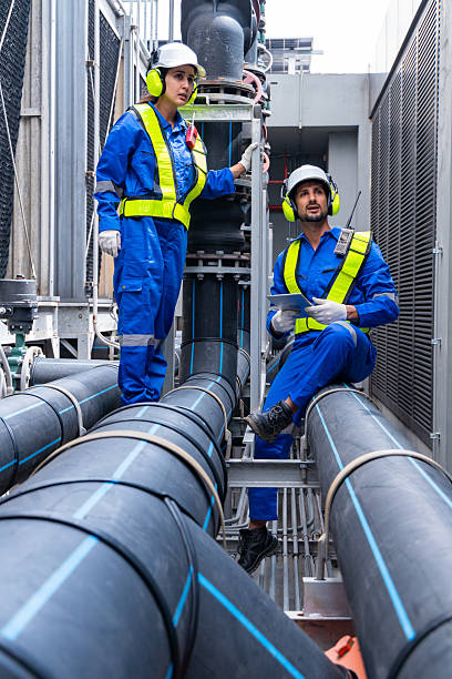 istock Engineers discussing blueprint near industrial pipes 2232697213