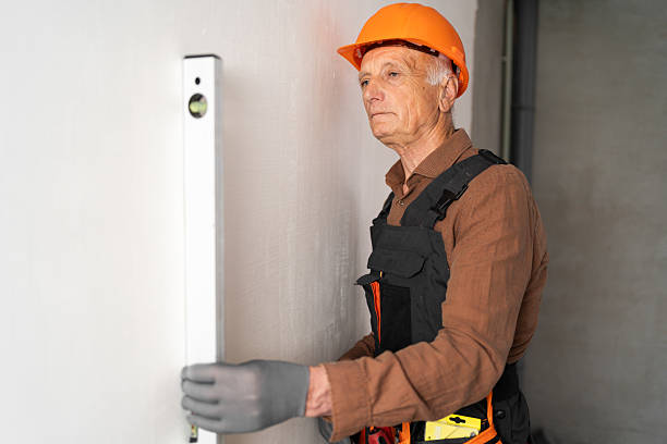 istock Builder elderly man using a spirit level measuring wall in new house 2232698206