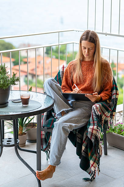 istock Relaxed young woman using tablet with stylus on balcony 2232699314