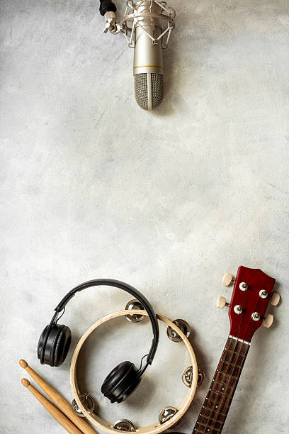 istock Musical instruments for band - small guitar, drumsticks and tambourine with studio microphone. Recording music in a studio 2232699767