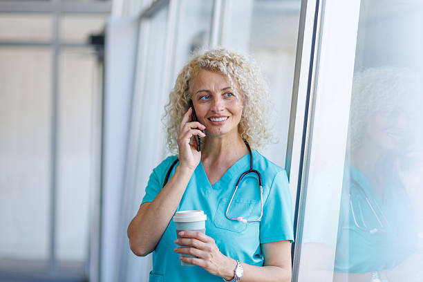 istock Doctor smiling while talking on phone and drinking coffee 2232700082