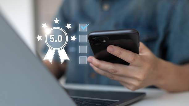 istock using a smartphone with a 5.0 rating review symbol. Customer satisfaction, online feedback, service quality, digital marketing, user experience, and business reputation improvement concept. 2232702309
