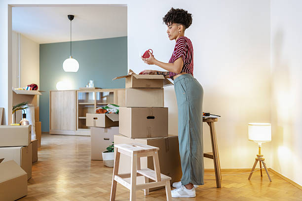 istock Woman unpacking boxes while settling into a new modern apartment 2232703116