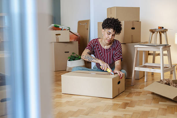 istock Young woman unpacking boxes in her new home 2232703445