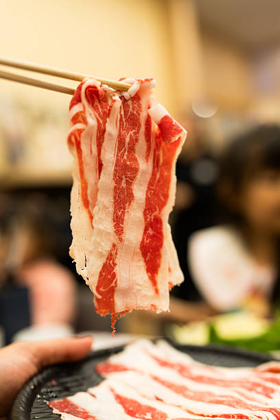 Use wood chopsticks fresh and raw beef meat ready for Shabu Shabu