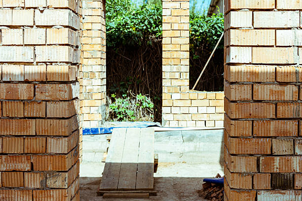 house under constraction with modern brick walls and holes for doors and windows. High quality photo