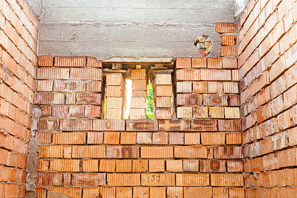 house under constraction with modern brick walls and holes for doors and windows. High quality photo
