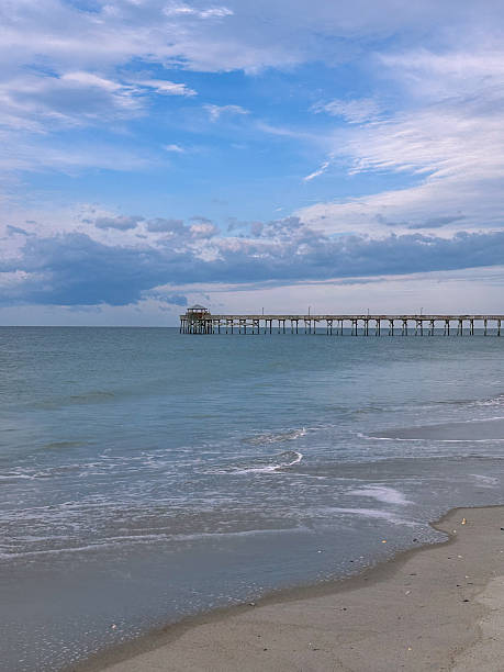 istock Ocean Pier Extending Over Calm Waves on a Sandy Beach 2232708869