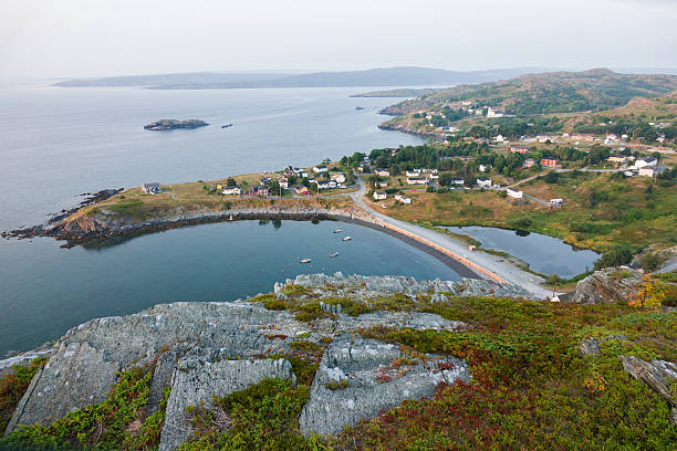 Homes stand at the base of Clowns Cove tolt or hill in the town of Freshwater Carbonear on Newfoundland's Avalon Peninsula as moored boats float on Clements Cove or Clown’s Cove in Conception bay.
