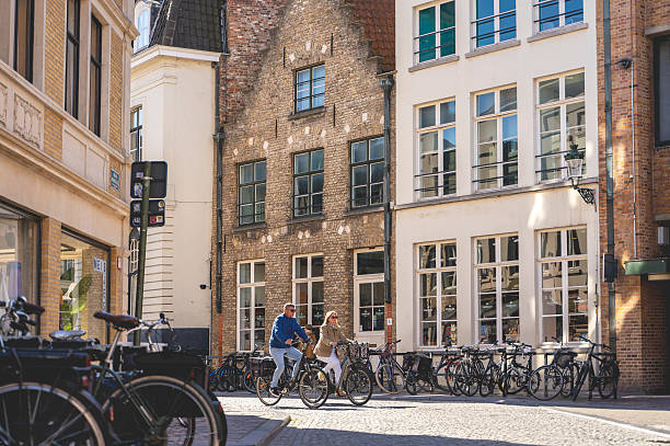 Bruges, Belgium- September 24, 2023. Medieval architecture and cozy narrow street with bicycles and walking people.