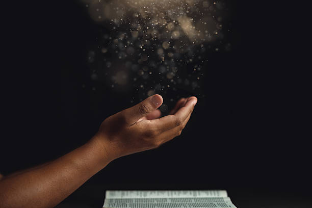 istock Open hand above a scripture with glowing light particles, representing blessings, faith, and divine inspiration. 2232714007