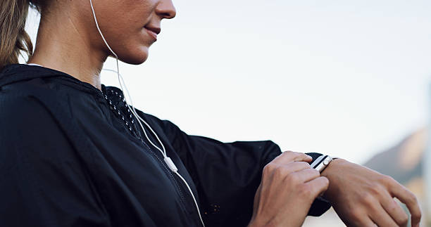 istock Runner, smart watch and progress with hands and woman for performance stats, location tracking and fitness. Music, stopwatch timer and workout with person and earphones in city for heart rate monitor 2232716737