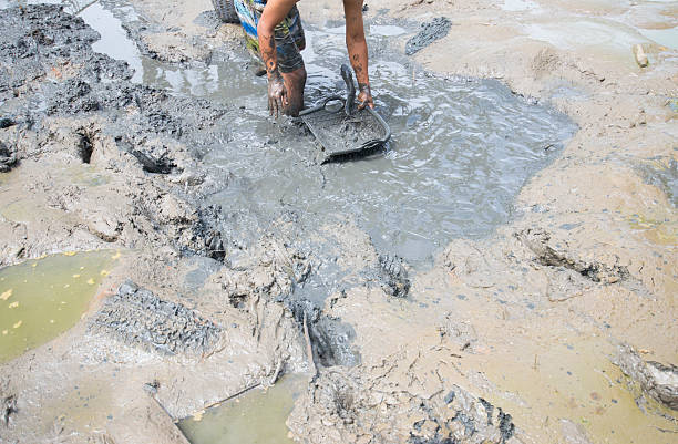 istock The worker is digging the soil in the mud at the construction site. 2232717142