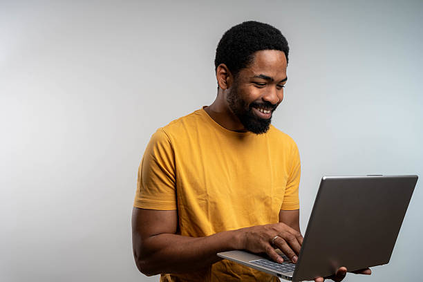 istock Confident male entrepreneur analyzing report over laptop while standing over white background 2232717489