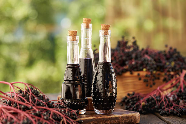 istock Bottles of black elder syrup with fresh elderberries outdoors on a summer day 2232720077