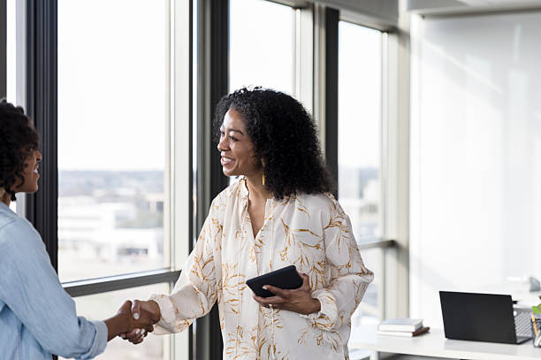 istock Two African American Women Shaking Hands in Office 2232722329