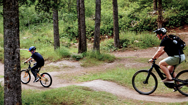 istock Father and son ride mountain bicycles on pathway in forest 2232722365