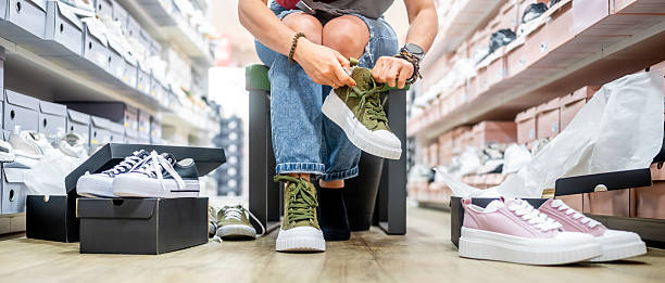 istock Woman Trying On Sneakers 2232731630