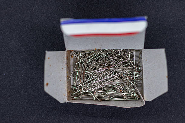 A number of stainless safety pins on white background.