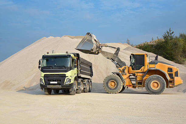 istock Yellow excavator loading stones in a truck 2232749819