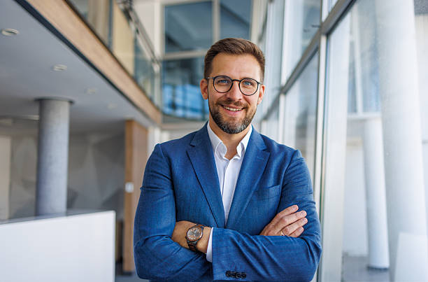 istock Confident businessman smiling with folded arms in a modern office 2232751725
