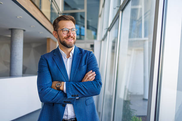 istock Confident businessman smiling with folded arms in modern office 2232751744