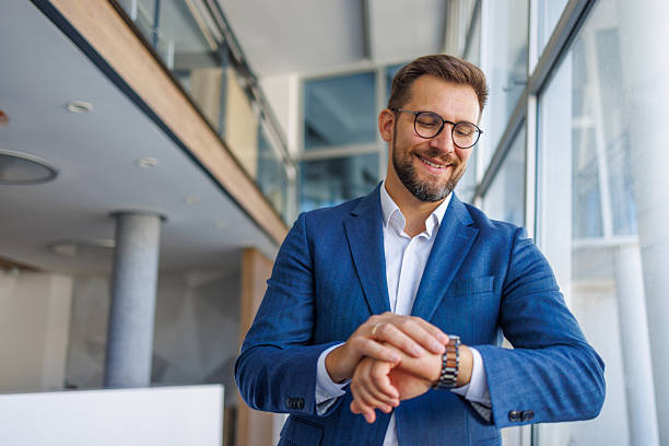istock Businessman checking time on wristwatch in modern office 2232751748