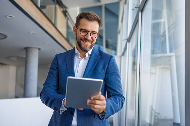 istock Businessman smiling and using digital tablet in office 2232751752