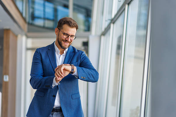 istock Businessman checking time on wristwatch in modern office 2232751834