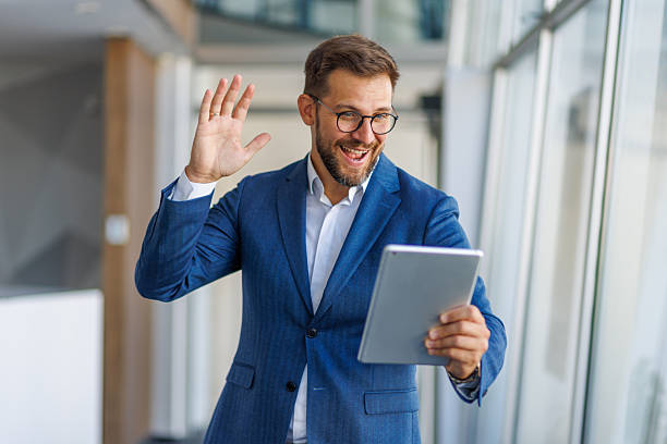 istock Businessman waving hand during video conference on tablet in office 2232752047
