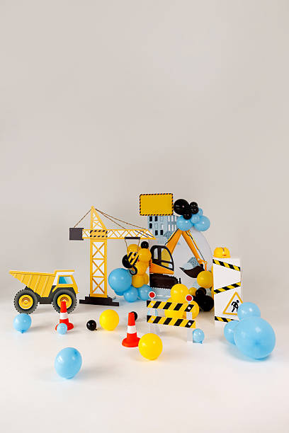 Creative construction-themed kids birthday party decoration featuring cartoon-style dump truck, crane